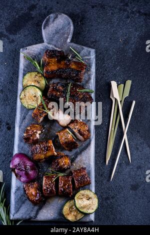 Gegrillte Schweinebauch auf Marmorbrett und Gemüse von oben Stockfoto