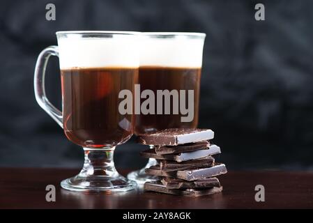 Traditioneller, starker irischer Kaffee auf Holzbalken mit dunkler Schokolade Stockfoto