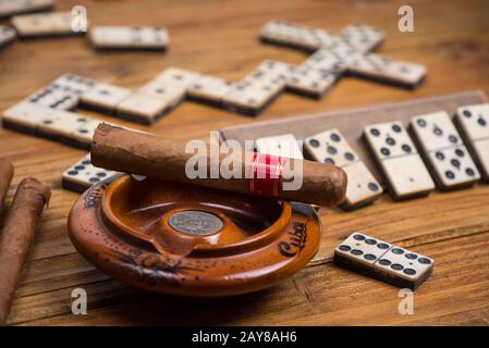 Kubanische Zigarre auf dem Tisch mit Dominospiel Stockfoto