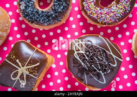 Kunsthandwerkliche Donuts auf dotka-pinkfarbenem Hintergrund Stockfoto