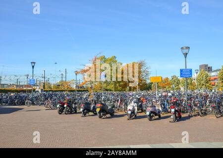 Venlo, Limburg-Niederlande - 13. Oktober 2018: Reihen geparktes Fahrrad und Motorräder in der niederländischen Stadt in der Nähe des Hauptbahnhofs. Stadtradfahren. Umweltfreundliches Transportmittel. Stockfoto