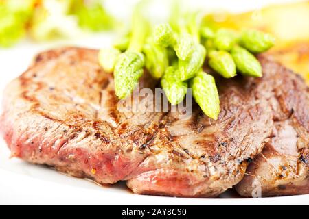 Wilder Spargel auf einem Steak Stockfoto