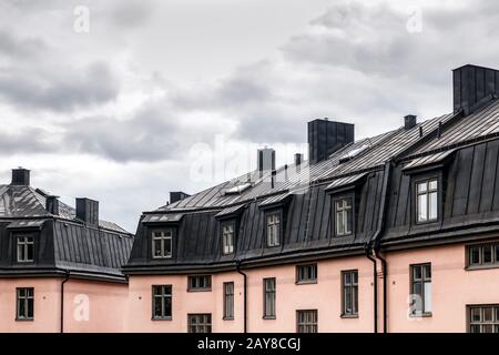 Pastellfarbene Wohnbauten mit schwarzen Dächern. Stockholm, Schweden. Stockfoto