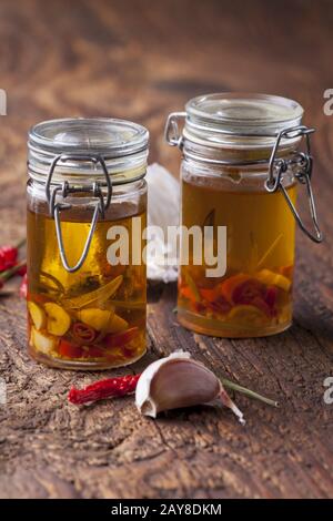 Olivenöl mit Knoblauch, Chili und Rosmarin Stockfoto