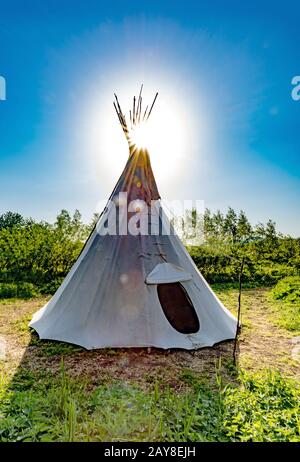 Indisches Zelt vor der Sonne in der Hintergrundbeleuchtung in einem grünen Wald Stockfoto