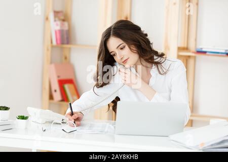 Close up Junge Büro Frau mit jemand sprechen auf Ihr Telefon, während der Blick in die Ferne mit glücklichen Gesichtsausdruck Stockfoto