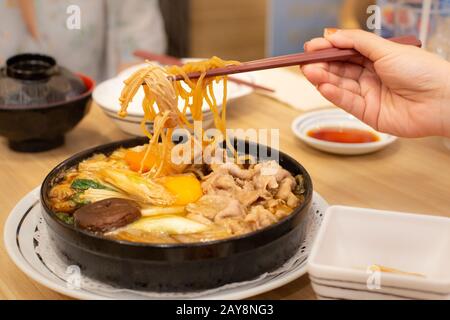 Zwei Personen sind der Verzehr von Schweinefleisch shabu oder Hot Pot. Zeit mit der Familie. Stockfoto