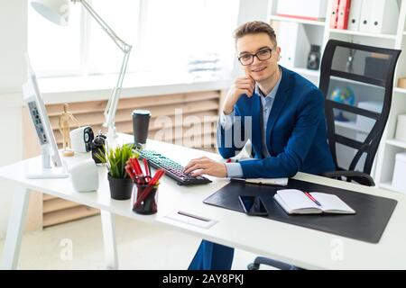 Junger Mann am Schreibtisch im Büro sitzen und Arbeiten am Computer. Stockfoto