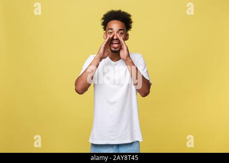 Positiver junger schwarzer Kerl, Student, Angestellter schreit Mund weit offen und seine Hände als Mundstück ins Gesicht. Port Stockfoto