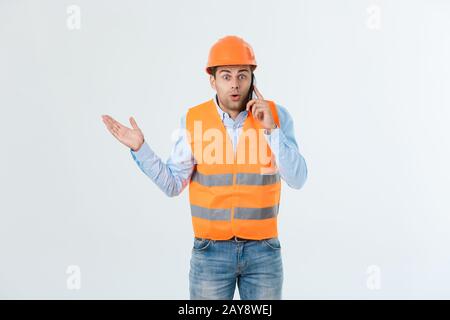 Bauingenieur spricht auf Handy, seriöse Erwachsene männliche Person mit Smartphone für die Kommunikation mit Arbeitern auf Buil Stockfoto