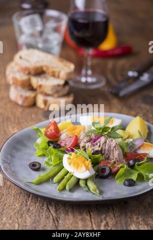 Salat Nikoise auf Holzgrund Stockfoto