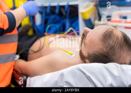 Notarzt Hände, das Anbringen der EKG-Elektroden auf der Brust des Patienten in der Ambulanz Stockfoto