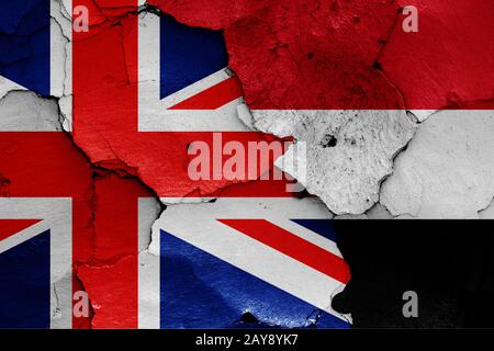 Flagge von Großbritannien und Jemen auf gerissene Wand gemalt Stockfoto