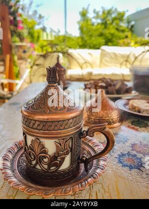 Traditioneller türkischer Kaffee und türkische Köstlichkeiten im traditionellen Kupferhandwerk. Seitenansicht. Stockfoto