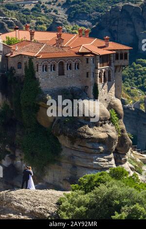 Bräutigam umarmte die Frau auf einem Felsen im Meteora- Porträt Stockfoto