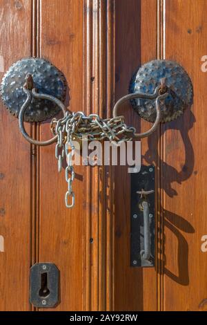 Alte braune Holztürgriffe, Kette und Schloss Stockfoto