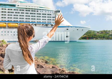 Fröhliche freudige Frau winkt Hallo oder auf Wiedersehen ein Handzeichen zum Kreuzfahrtschiff. Karibischer Luxus Urlaub Konzept. Boot verlässt den Hafen, Touristen begrüßen. Stockfoto