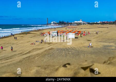 Blick von der letzten Düne auf den Strand und den Leuchtturm von Maspalomas. Stockfoto