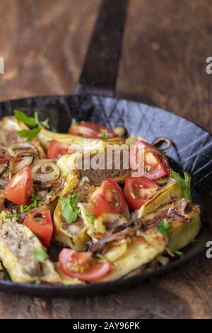 Schwäbische Maultaschen mit Zwiebeln in einer Pfanne Stockfoto