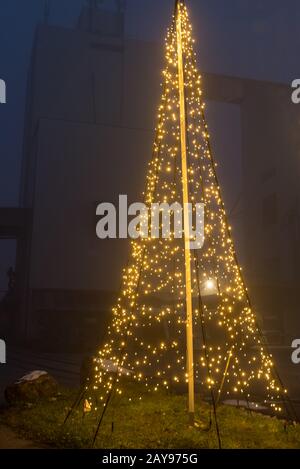 Große LED-Lichterkette am Weihnachtsbaum als Dekoration im Freien Stockfoto