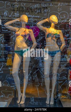 Mannequins hinter einer beschrifteten Glasscheibe. Stockfoto