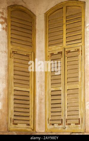 Verwittertes Holz vintage Grunge gelben Fensterläden des alten Hauses Ecke Wand Fassade Nahaufnahme Stockfoto