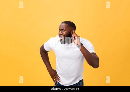 Kopfschuss von Goofy überraschte bugsäugige junge dunkelhäutige Mann-Studentin mit beiläufigem weißem T-Shirt, die schockiert auf die Kamera starrte Stockfoto