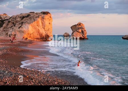 Ein Junge spielt am Strand an den Felsen Petra tou Romiou, in Paphos, Zypern. Stockfoto