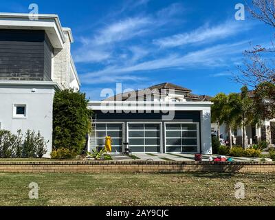 Orlando, FL/USA-2/10/20: Ein Mann wäscht oder wäscht ein Haus in einer Nachbarschaft, um Schimmel und Schmutz zu entfernen. Stockfoto