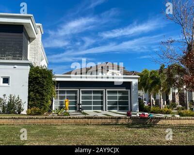 Orlando, FL/USA-2/10/20: Ein Mann wäscht oder wäscht ein Haus in einer Nachbarschaft, um Schimmel und Schmutz zu entfernen. Stockfoto