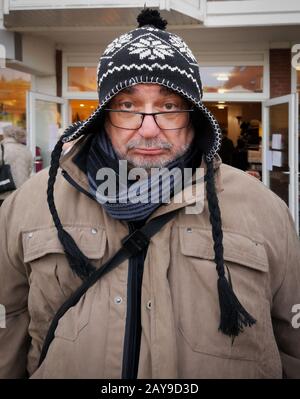 Alter Mann mit mürriger Optik und gestricktem Hut. Stockfoto