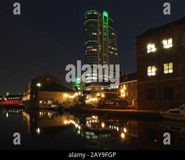 Stadtbild Blick auf die nächtliche Kanalwharfe in leeds mit beleuchteten Gebäuden und Brücke Stockfoto