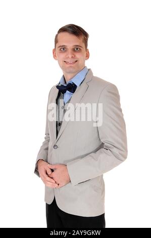 Junger Mann, der in einer grauen Jacke mit Fliege steht Stockfoto