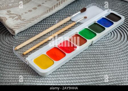 Aquarellfarben in einem Etui und Bürsten. Stockfoto