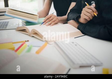 Lern-, Bildungs- und Schulkonzept. Junge Frau und Mann, die zu einem Test oder einer Prüfung studieren. Tutorenbücher mit Freunden. Der Campus junger Studenten hilft Frie Stockfoto