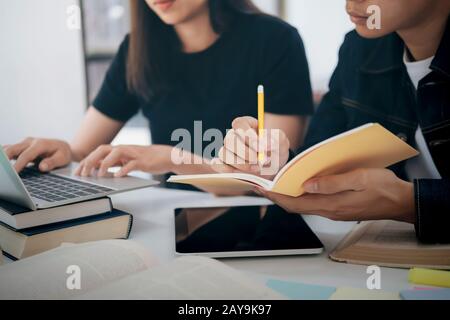 Lern-, Bildungs- und Schulkonzept. Junge Frau und Mann, die zu einem Test oder einer Prüfung studieren. Tutorenbücher mit Freunden. Der Campus junger Studenten hilft Frie Stockfoto
