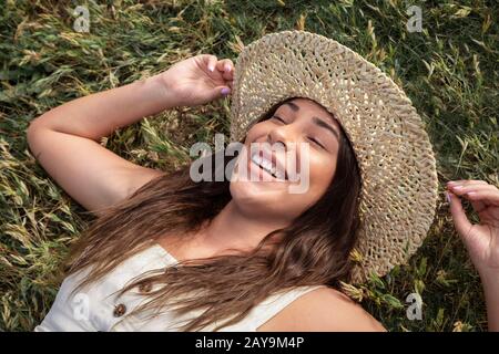 Hübsche Latina Frau lacht im Gras Stockfoto