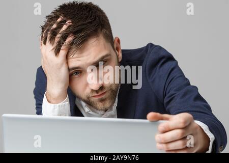 Geschäftskonzept - Porträt schön stressig business Mann in Anzug Schock bei der Arbeit, die in den Laptop zu schauen. Weißer Hintergrund. Stockfoto