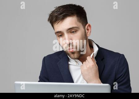 Geschäftskonzept - Porträt schön stressig business Mann in Anzug Schock bei der Arbeit, die in den Laptop zu schauen. Weißer Hintergrund. Stockfoto