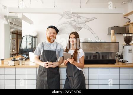 Kaffee Geschäftskonzept - glückliche junge Barkeeper, baristi Ready Service an modernen Coffee Shop zu geben. Stockfoto