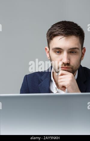 Geschäftskonzept - Portrait ein stressiger Business man in Anzug Schock vor dem Laptop im Büro. Weißer Backg Stockfoto