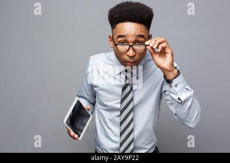 Geschäftskonzept - Glücklich aussehenden professionelle afrikanische amerikanische Geschäftsmann holding Tablet mit überraschenden Gesichtsausdruck. Stockfoto