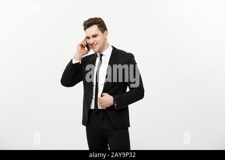 Gut aussehender Geschäftsmann im Anzug am Telefon über isoliert weißer Hintergrund. Stockfoto