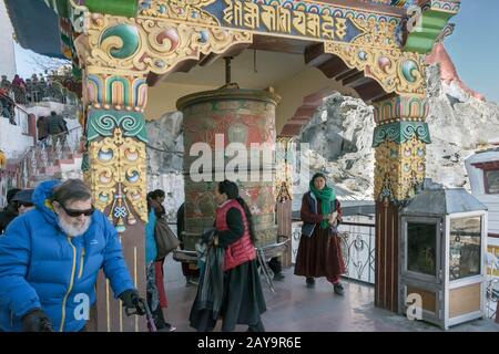 Festival-Besucher drehen ein großes Gebetsrad, Spituk Gompa, Leh Bezirk, Ladakh, Indien Stockfoto