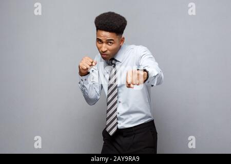 Geschäftskonzept - Zuversichtlich, fröhlicher junger afrikanischer Amerikaner im Boxen poseture über grauen Hintergrund. Stockfoto