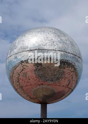 Ein riesiger Glitterball an der blackpool-promenade mit blauem Himmel und Spiegelbild der Stadt im Spiegel Stockfoto