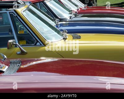 Nahaufnahme der Hauben- und Windschutzscheiben einer Reihe von Oldtimer-Triumph-Sportwagen Stockfoto