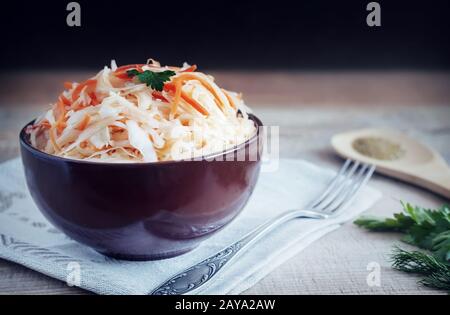 Mit Karotten in einem keramischen Cup Sauerkraut. Stockfoto