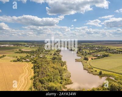 Panoramablick mit farmfields, Länder, den Fluss auf einem Hintergrund blau bewölkten Himmel in einem Sommertag. Stockfoto