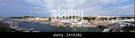 Ein weiter Panoramablick auf die Stadt ciutadella auf menorca, der Boote entlang des Kanals zeigt Stockfoto